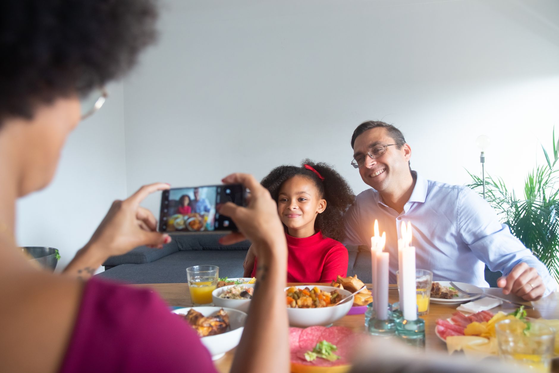 A family capturing a memorable dinner moment using a smartphone, creating lasting memories.