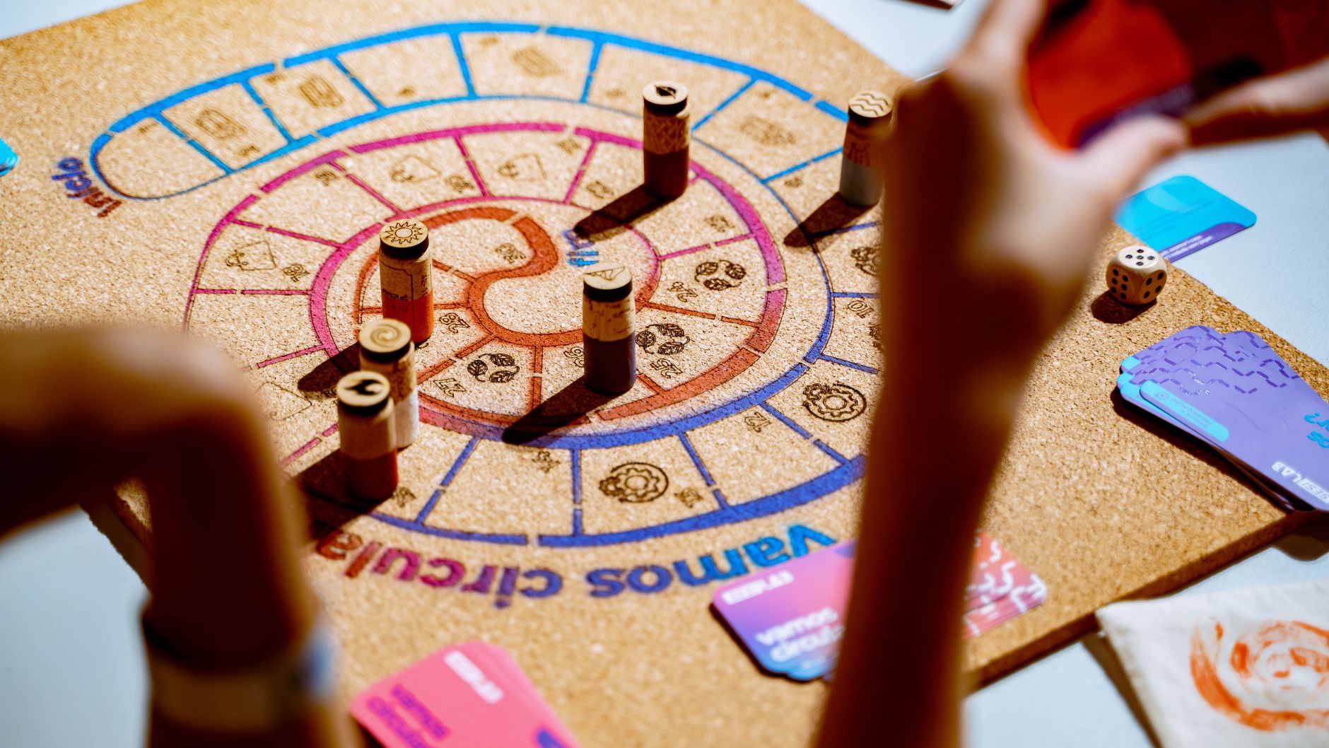 Players engaging in a vibrant strategy board game with colorful pieces and cards.