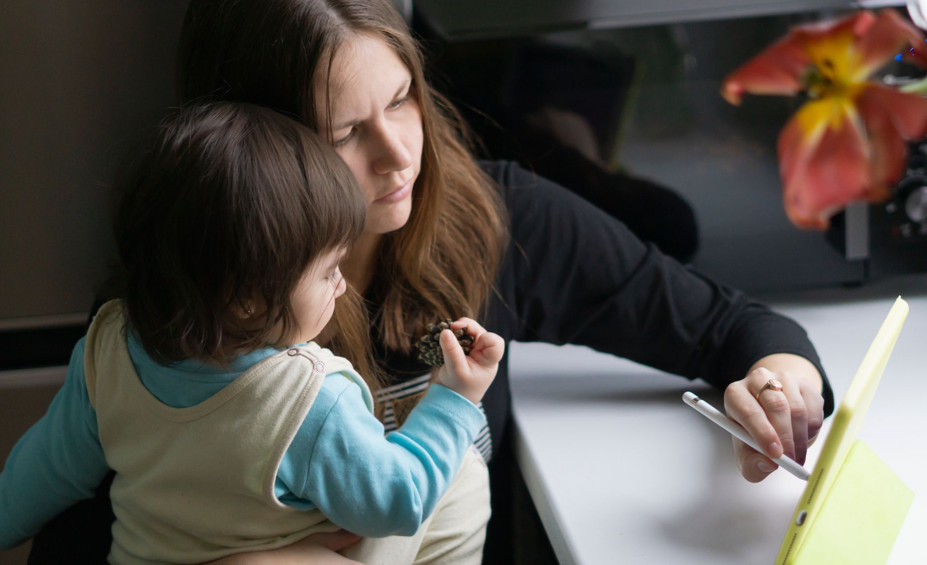 A mother and child engage with a tablet, capturing a moment of modern parenting.