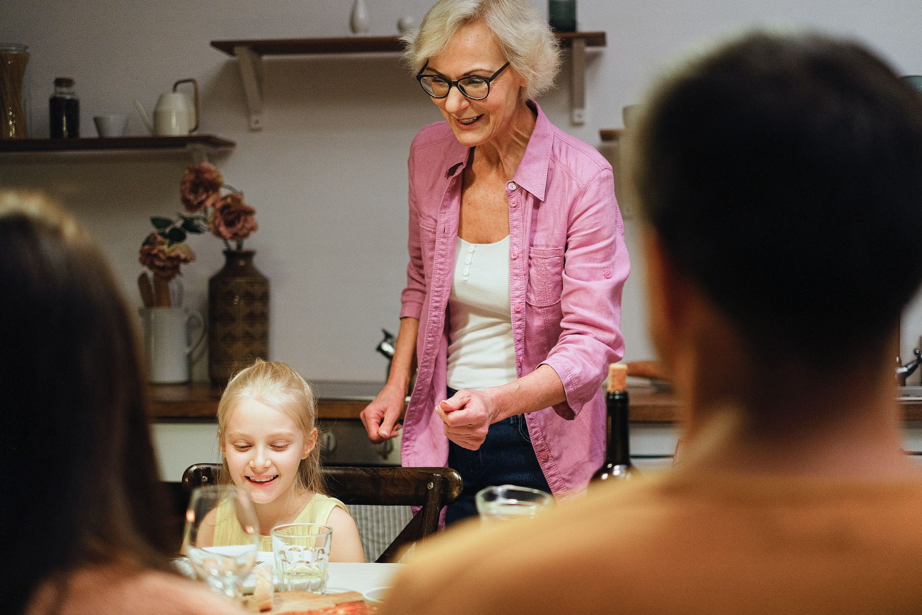 A joyful family gathering around the dinner table, showcasing togetherness and warmth indoors.