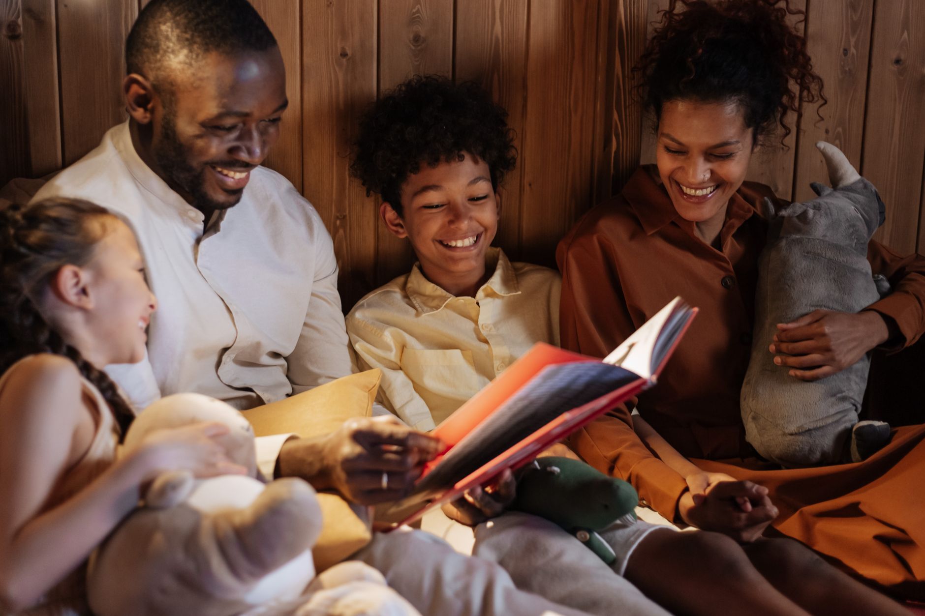 A joyful family enjoys a cozy bedtime story together in a warm home setting.