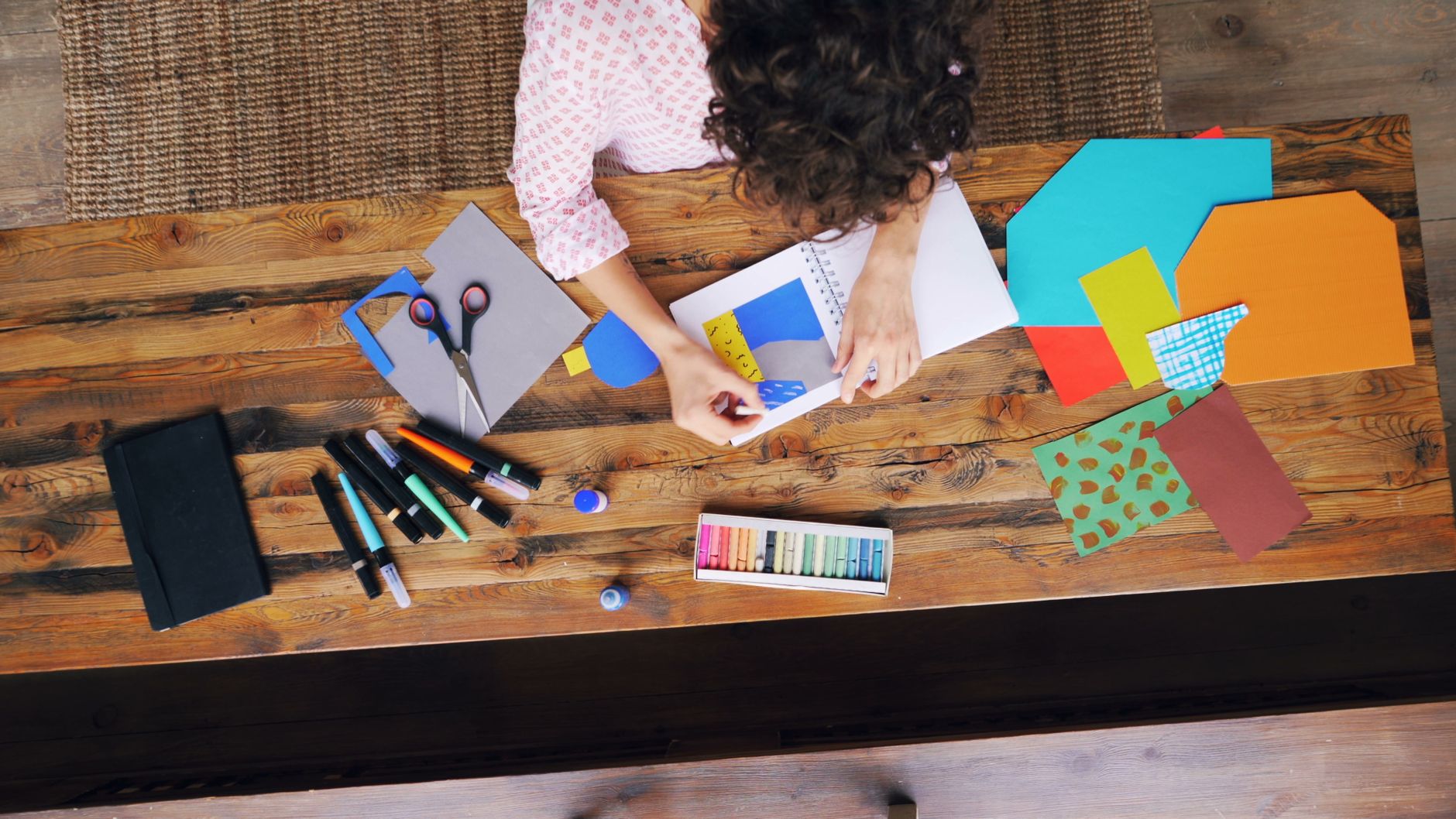 Crafting station view from above showing art supplies and creative process.