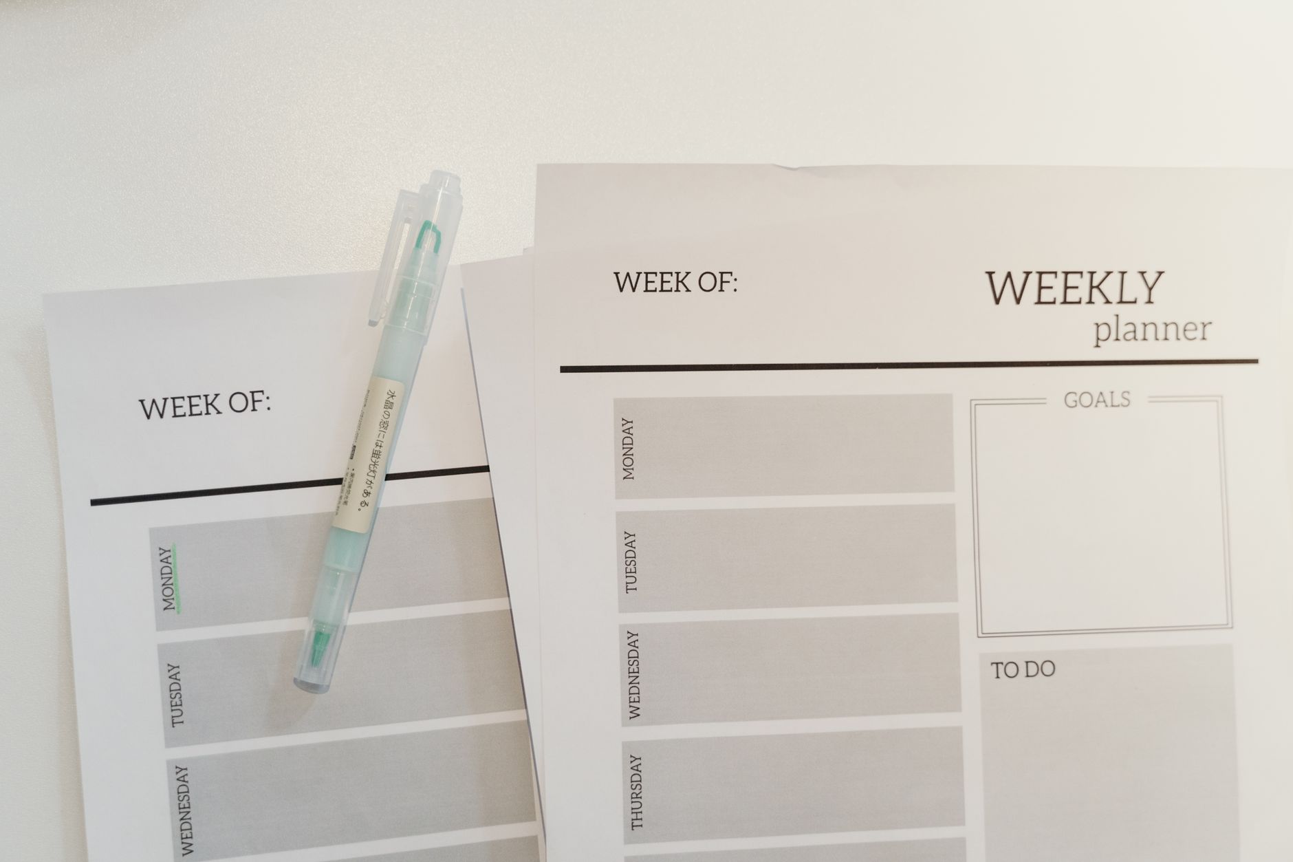 Organized weekly planner sheets with a pen for efficient scheduling and goal setting.